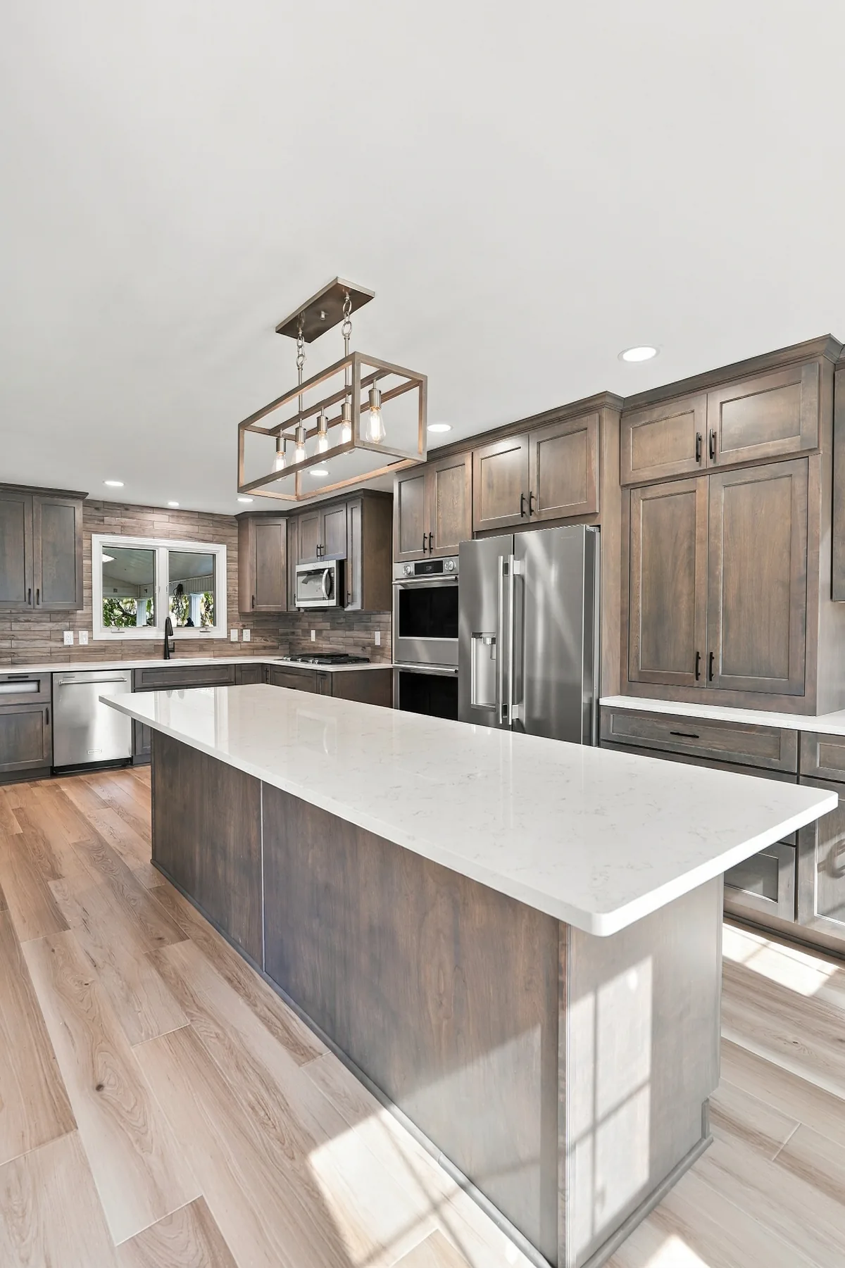 Rectangular pendant light above the white kitchen island countertop